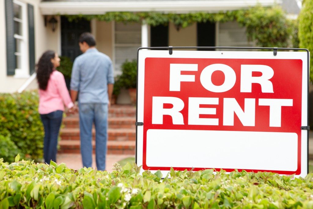 Couple with "for rent" sign