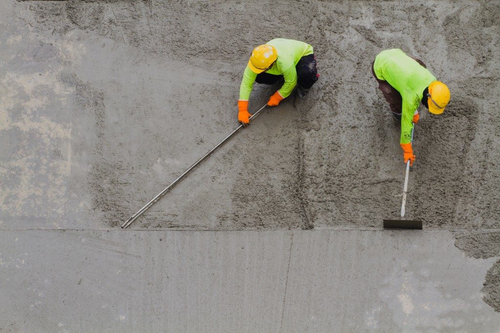 2 concrete workers spreading cement