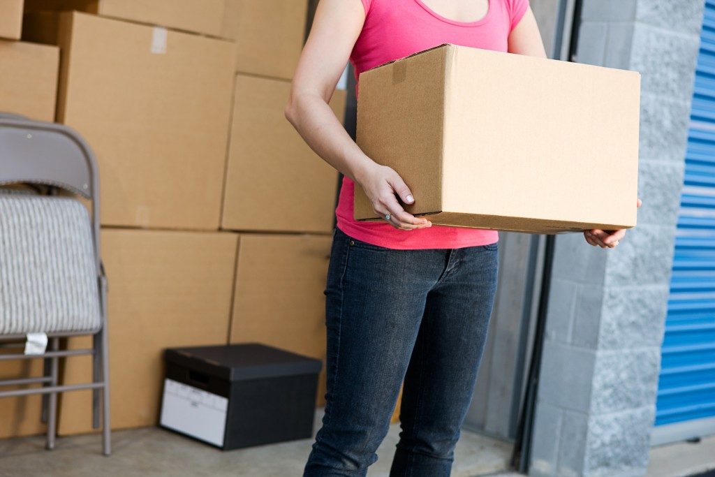 Woman holding box in storage unit