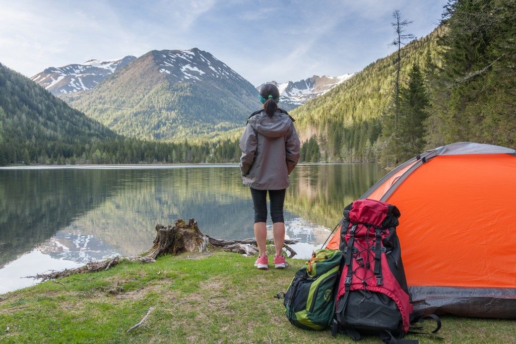 woman camping in a mountain beside the lake
