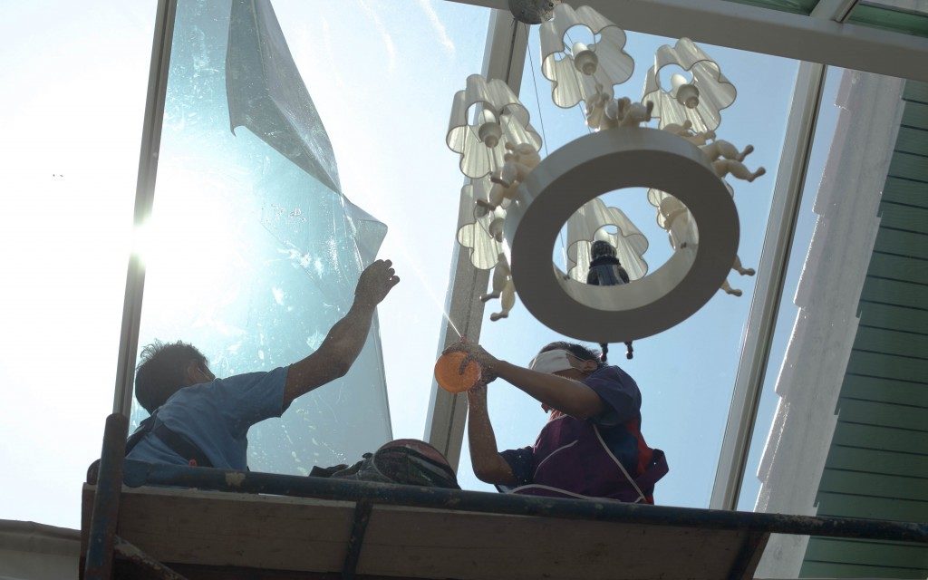 workers putting window tint on conservatory window