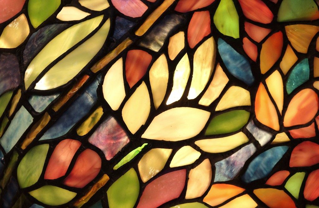 Glowing Glass Art. Backlit hand crafted glass art from church window with flowers and vivid colors.