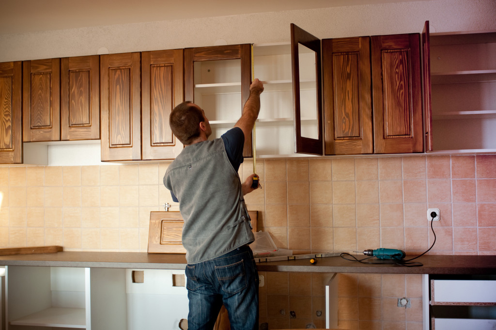 man fixing kitchen cabinet