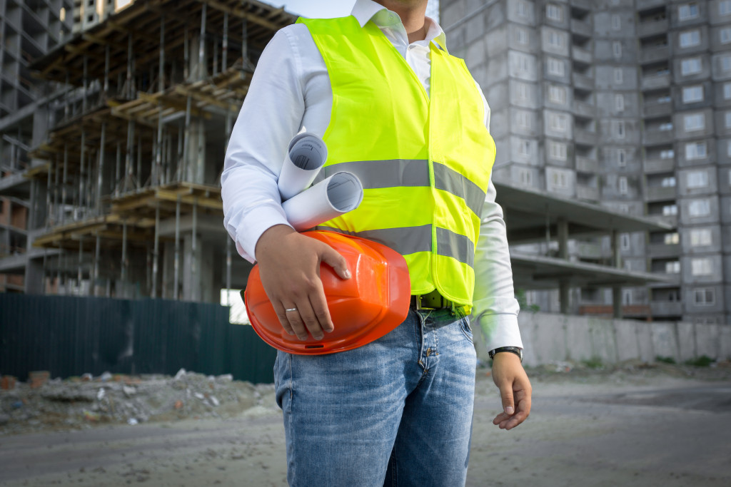 construction worker with blueprints in his arms