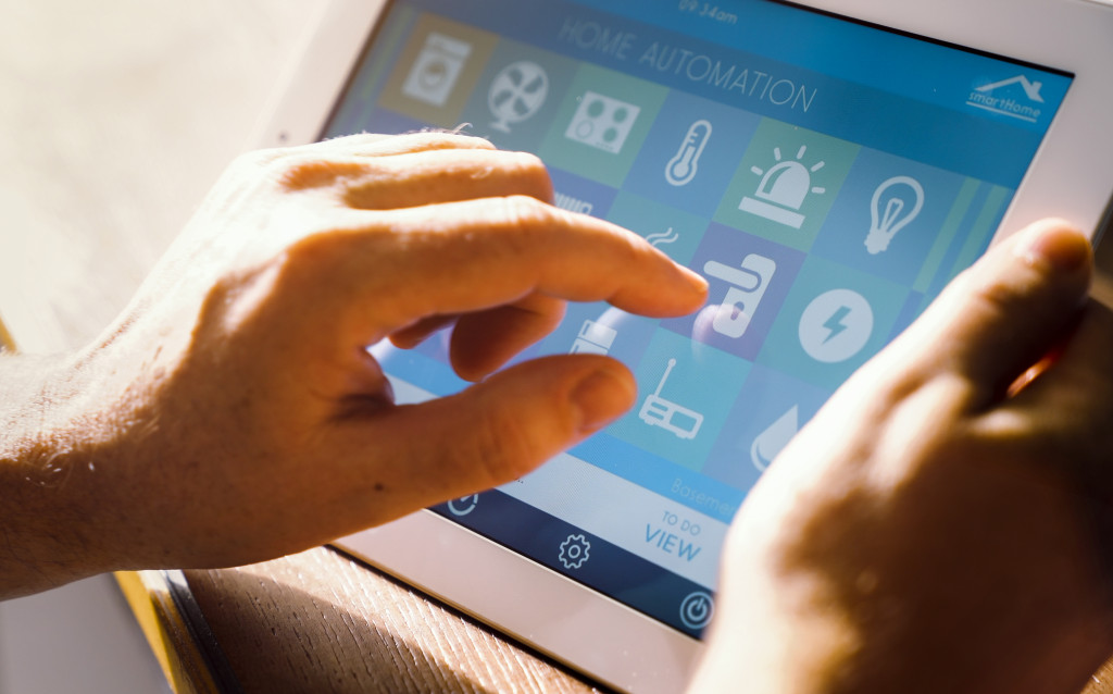 A person using a smart home feature of locking a door on a tablet