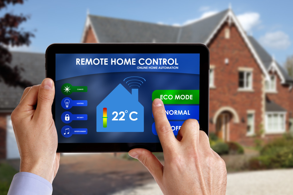 A man using a tablet to control settings in his smart appliances at home