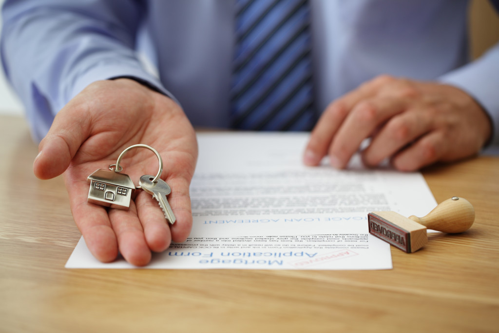 A man holding a house-shaped key ring