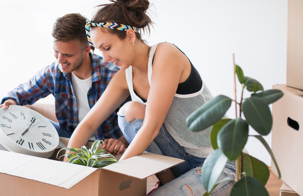 moving day for young couple packing things in box 