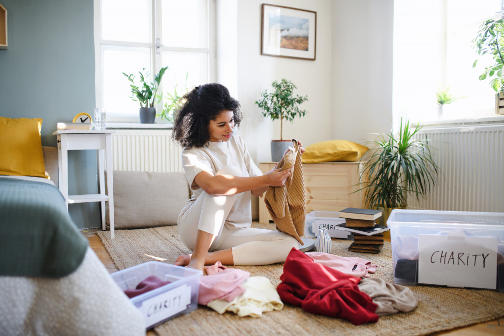 Young woman decluttering and organizing her belongings inside the home.