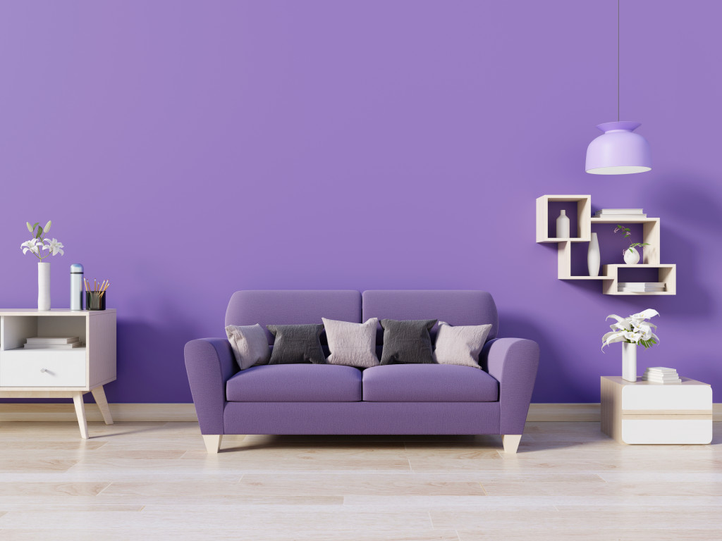 A living room with a violet wall and couch