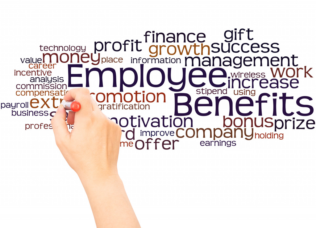 hand writing employee benefits on a white board