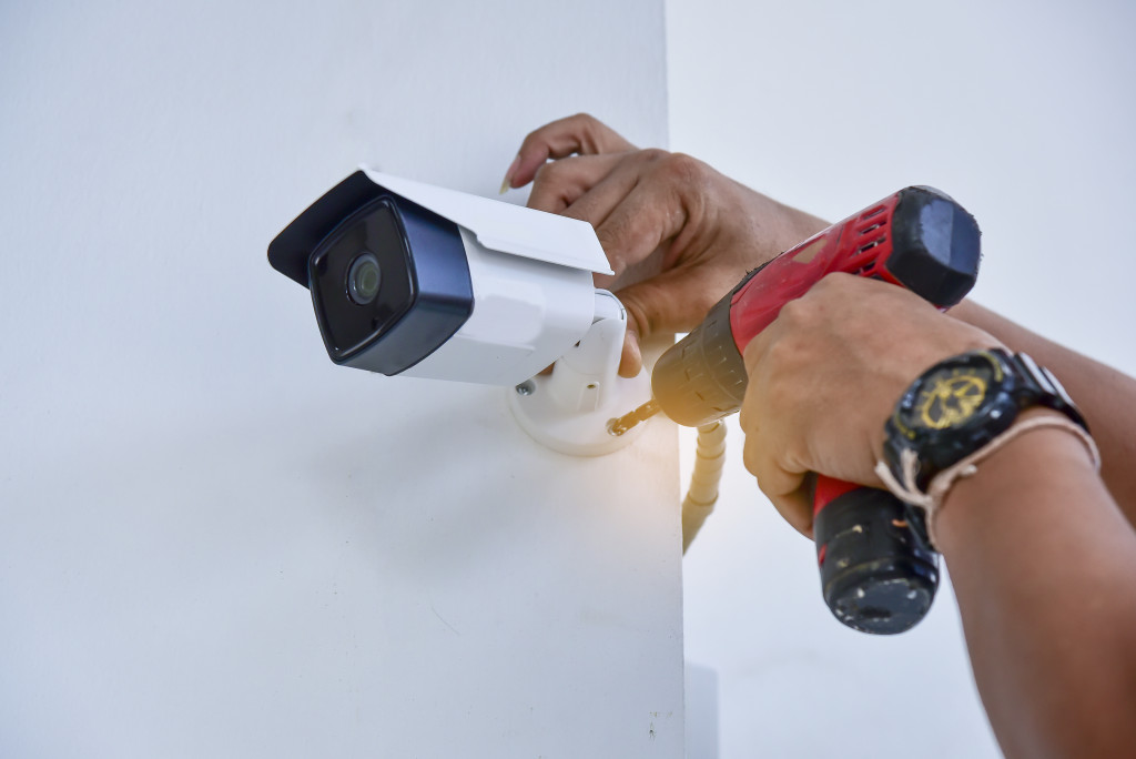 a man drilling a cctv camera