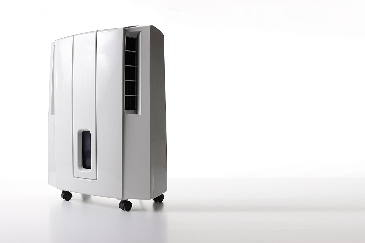 Dehumidifier placed in an empty room with white walls.