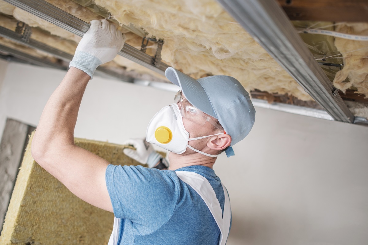 A worker installing insulation on a roof