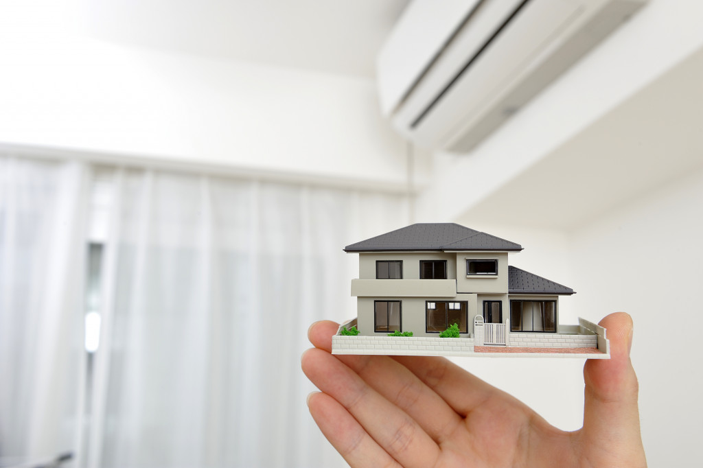 miniature house model held inside a white room