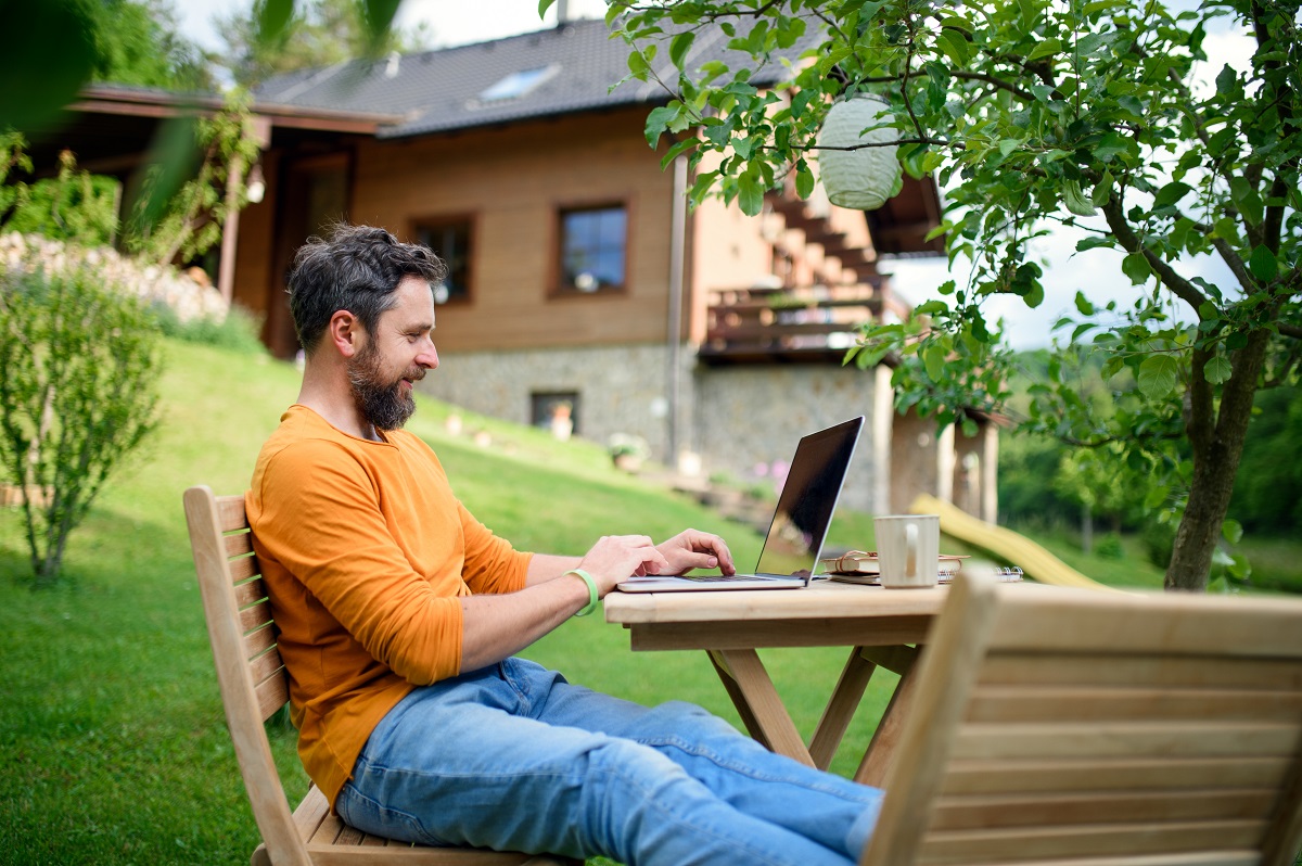 man with laptop working outdoors in garden