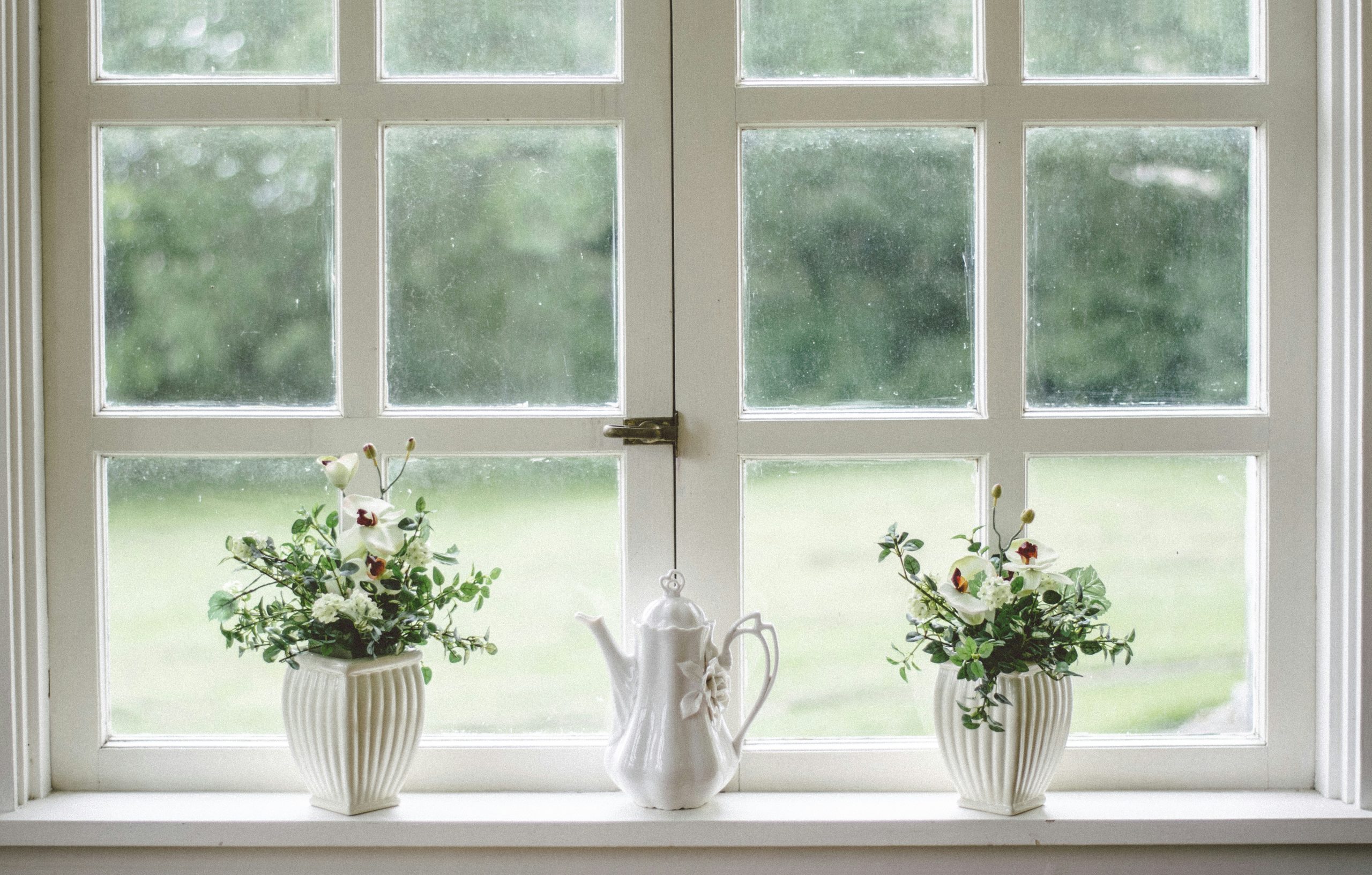 flower vases by large windows